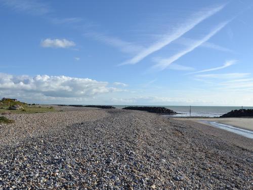 a rocky beach with the ocean in the background at Lo-Tide in Middleton-on-Sea