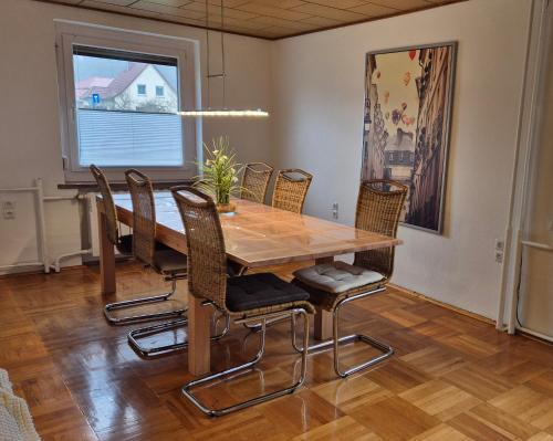 a dining room with a wooden table and chairs at Am Trebeteich in Pulsnitz