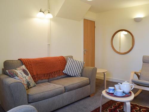 a living room with a couch and a table at Valeview Cottage in Great Malvern