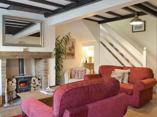 a living room with two couches and a fireplace at Church Court Cottage in Beeford