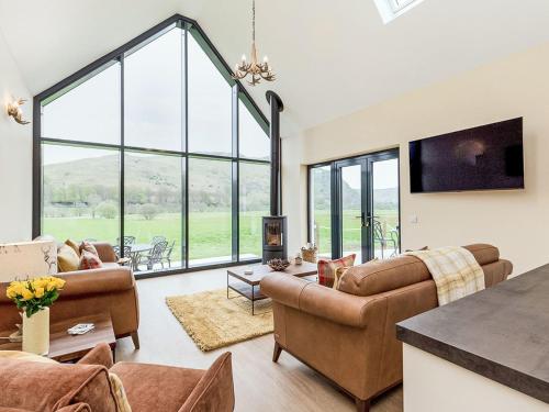 ein Wohnzimmer mit Möbeln und großen Fenstern in der Unterkunft Holiday Home Balbeg Cottage by Interhome in Straiton