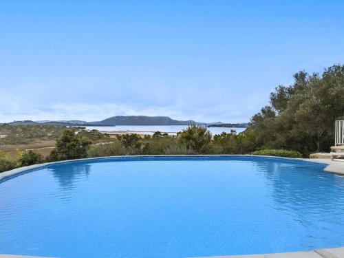 une grande piscine bleue avec vue sur l'eau dans l'établissement Villa Casa Di Sogno by Interhome, à Porto-Vecchio