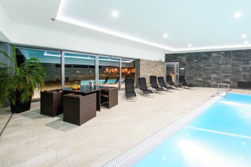a pool in a hotel with chairs and a swimming pool at Sport Hotel in Dolní Morava
