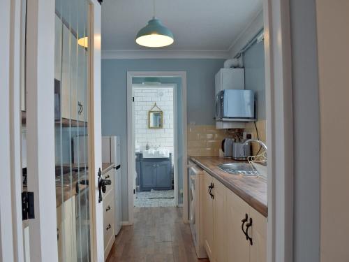 a kitchen with a sink and a counter top at Florence Cottage in Pakefield