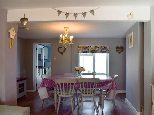 a dining room with a table and chairs at Florence Cottage in Pakefield