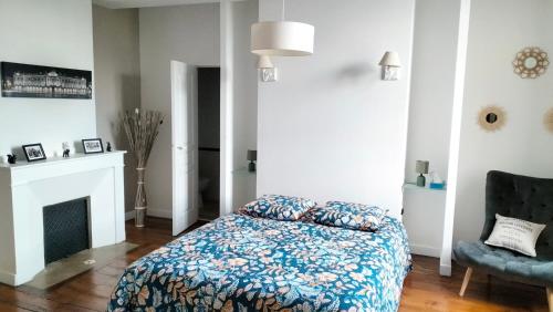 a bedroom with a bed and a chair and a fireplace at Le puits de Jussens in Castelnau-de-Lévis