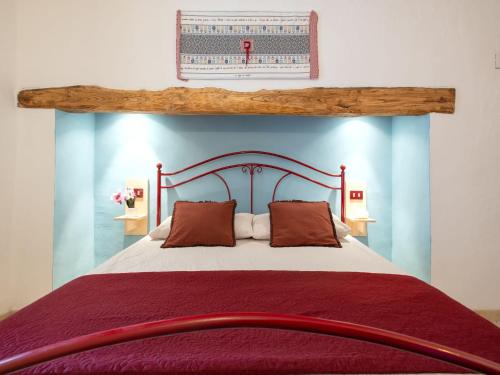a bedroom with a large bed with a wooden headboard at Holiday Home Francesca by Interhome in Vignola Mare