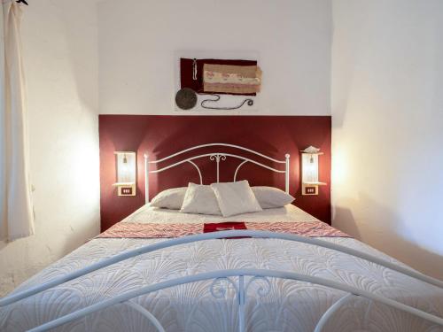a bedroom with a large bed with red walls at Holiday Home Francesca by Interhome in Vignola Mare