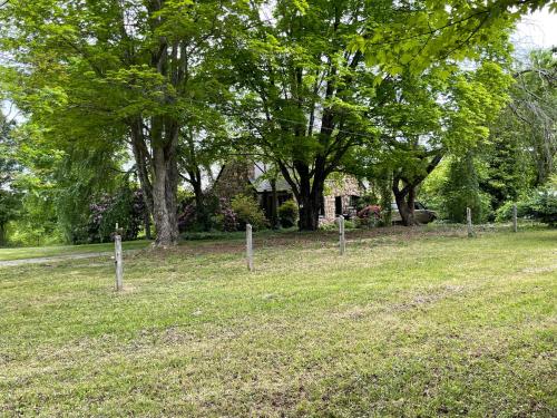 a fence in a field with trees and a house at Asheville Urban Farmhouse Entire Home 4 mi to DT in Asheville