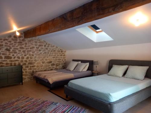 una camera da letto con due letti e un muro di pietra di Bâtisse Ardechoise avec piscine a Saint-Prix