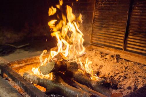 a fire in a grill with flames in it at Medjugorje Hotel & Spa in Međugorje