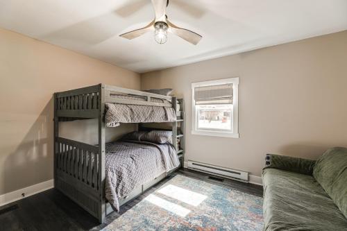 a bedroom with a bunk bed and a ceiling fan at Private Beach and Fishing Pier Wicomico River House in Chance