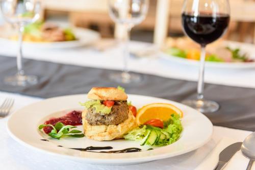 a plate of food on a table with wine glasses at Sport Hotel in Dolní Morava