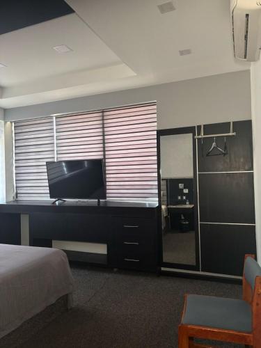 a bedroom with a bed and a television and a mirror at Hotel You Koso in Tijuana