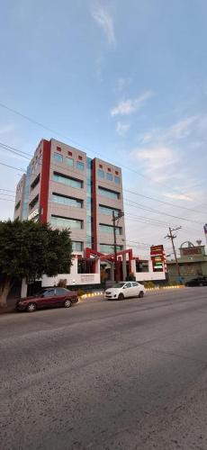 a street with cars parked in front of a building at Hotel You Koso in Tijuana