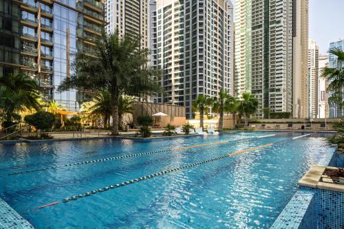 a large swimming pool in a city with tall buildings at Marina Gate Luxury Full Marina & Sunset Sea Views in Dubai
