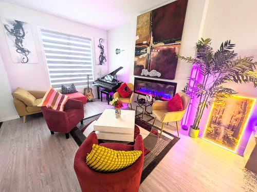 a living room with red chairs and a tv at Edith Gate Luxe Bedroom 2 Homestay in Calgary