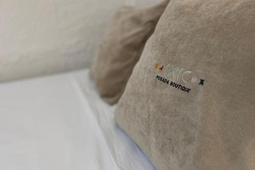 a pillow sitting on top of a bed at Ixic posada boutique in Zihuatanejo