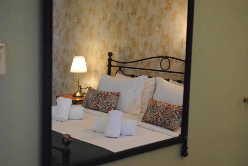 a mirror reflecting a bed with white pillows at Andromachi's beloi hotel in Vitsa