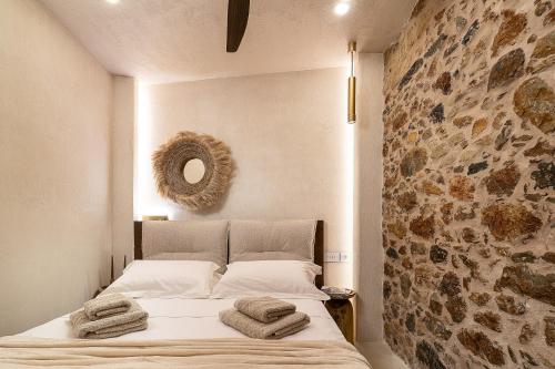 a bedroom with a bed with towels on it at Pappous & Giagia Central Suites, By IdealStay Experience in Malia