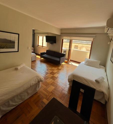 a hotel room with two beds and a television at Hotel Plaza Ñuñoa in Santiago