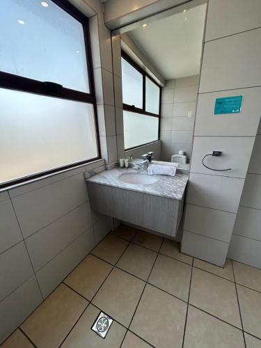 a bathroom with a sink and a window at Hotel Plaza Ñuñoa in Santiago
