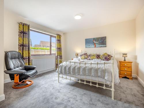 a bedroom with a bed and a chair and a window at Casa Mia in Terrington Saint John