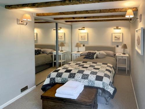 a bedroom with two beds and two tables and a mirror at The Basket Loft in Newlyn