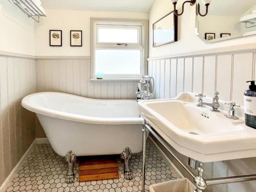 a bathroom with a tub and a sink at The Basket Loft in Newlyn