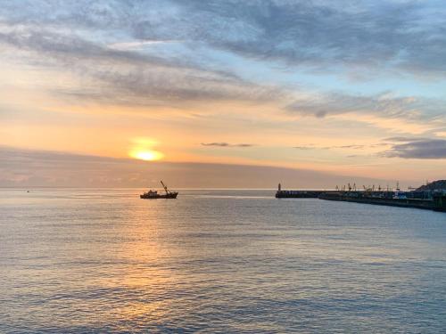 a boat in the water with the sunset in the background at The Basket Loft in Newlyn