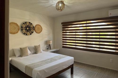 a bedroom with a bed and a large window at Ixic posada boutique in Zihuatanejo