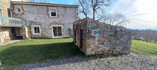a stone wall in front of a house at La Maison de Campagne de Léobin in Véranne