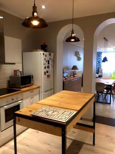 une cuisine avec une table en bois et un réfrigérateur dans l'établissement Appartement de standing bord de plage malo, à Dunkerque