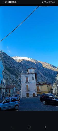 a building with cars parked in front of a mountain at Casa Fara in Fara San Martino