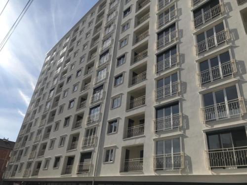 a tall white apartment building with balconies at Dabi's apartment in Ferizaj
