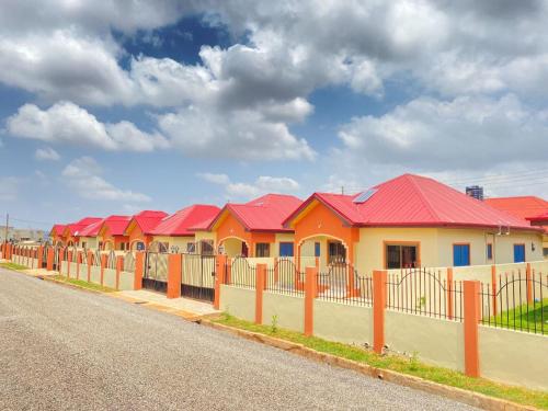 a row of houses with red roofs on a street at 2 bedroom house Accra in Apenkwa