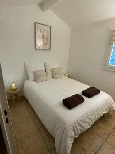 une chambre avec un grand lit blanc avec deux oreillers dans l'établissement pretty villa club cosy Bandol, à Bandol