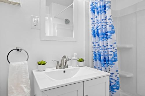 a bathroom with a sink and a shower curtain at Modern and Spacious House Pittsburgh in Pittsburgh