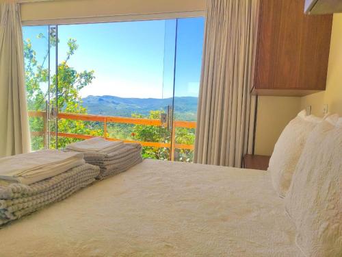 a bedroom with a bed and a large window at Pousada Casa de Maitreya in Alto Paraíso de Goiás
