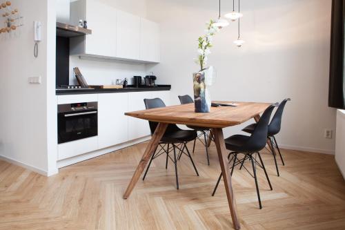 a kitchen and dining room with a wooden table and chairs at The Duke Boutique Apartments in Den Bosch