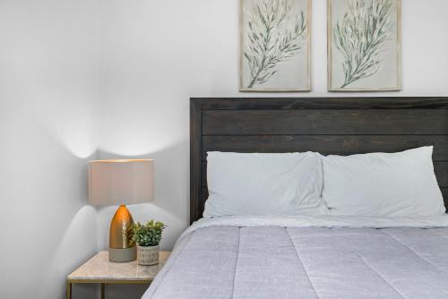 a bed with a wooden headboard and a lamp on a table at Modern and Spacious House Pittsburgh in Pittsburgh