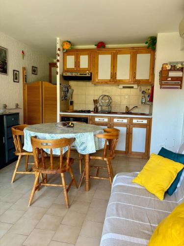une cuisine et une salle à manger avec une table et des chaises dans l'établissement Appartement Bormes-les-Mimosas - Résidence avec piscine, à Bormes-les-Mimosas