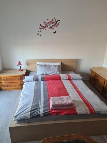 a bed with a striped comforter and two towels at Private Zimmer in einer Wohngemeinschaft für die Nacht in der Nähe des Flughafens Halle Leipzig in Schkeuditz