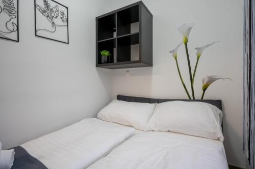 a bedroom with a bed with white sheets and a window at Villa Krems Wachau Apartments an der historischen Stadtmauer in Krems an der Donau