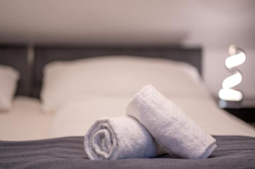 a pile of towels sitting on top of a bed at Villa Krems Wachau Apartments an der historischen Stadtmauer in Krems an der Donau
