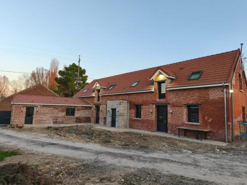 un bâtiment en briques avec un banc devant lui dans l'établissement Les gîtes de Pierre, à Saint-Christ-Briost