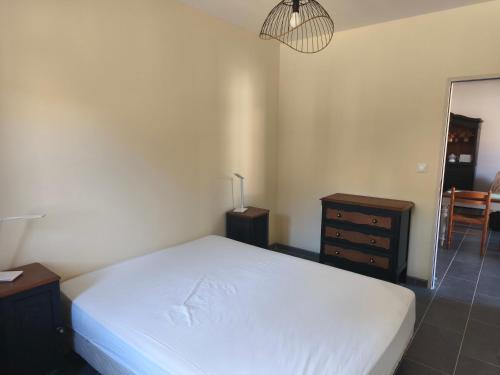 une chambre avec un lit, une commode et un miroir dans l'établissement Les gîtes de Pierre, à Saint-Christ-Briost