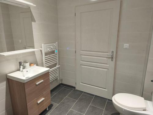 une salle de bain avec des toilettes, un lavabo et une porte dans l'établissement Les gîtes de Pierre, à Saint-Christ-Briost