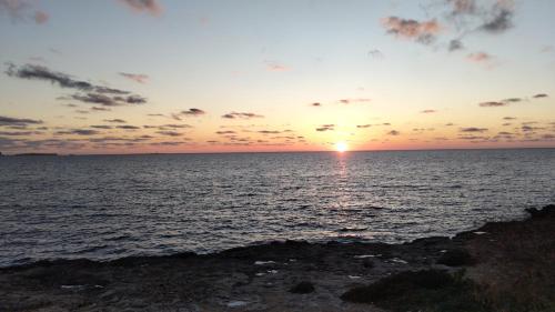 a sunset over the ocean with the sun setting at Case vacanze LULU in Seclì