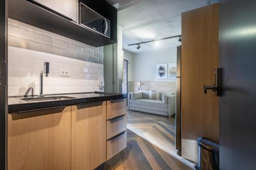 a kitchen with a sink and a living room at Housi Faria Lima in Sao Paulo